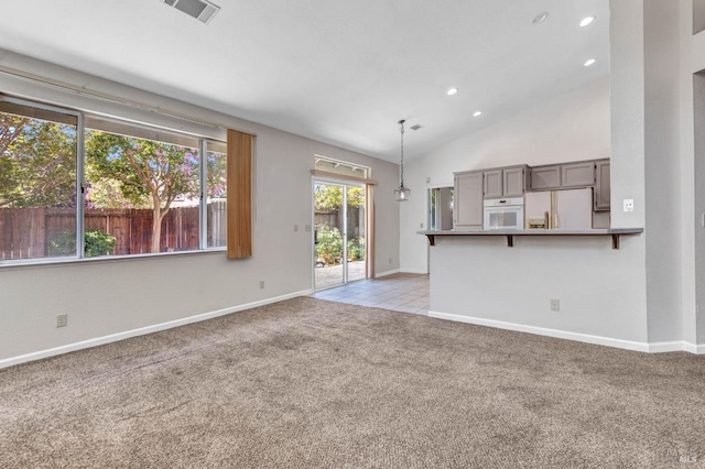 unfurnished living room featuring light colored carpet and high vaulted ceiling