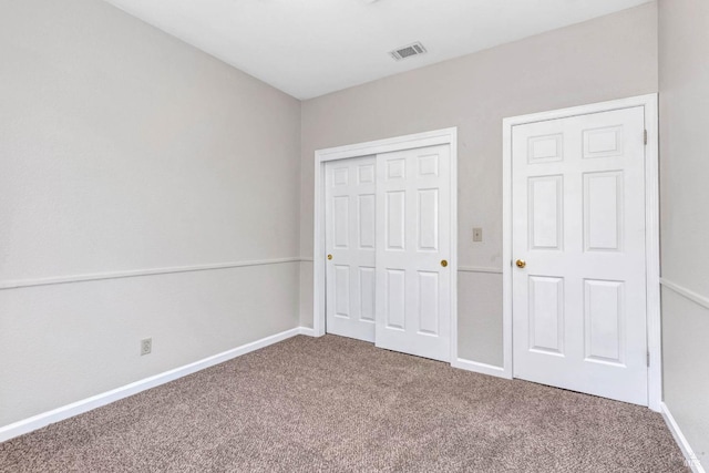 unfurnished bedroom featuring carpet flooring and a closet