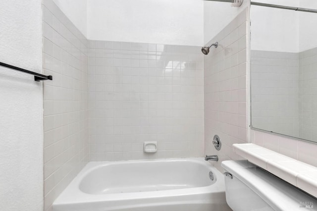 bathroom featuring tiled shower / bath and toilet