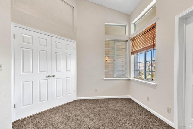 unfurnished bedroom with a closet, lofted ceiling, and carpet