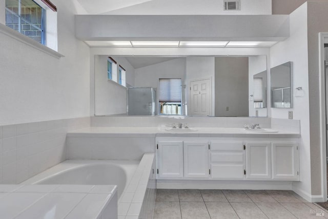 bathroom featuring lofted ceiling, vanity, a wealth of natural light, and tile patterned floors