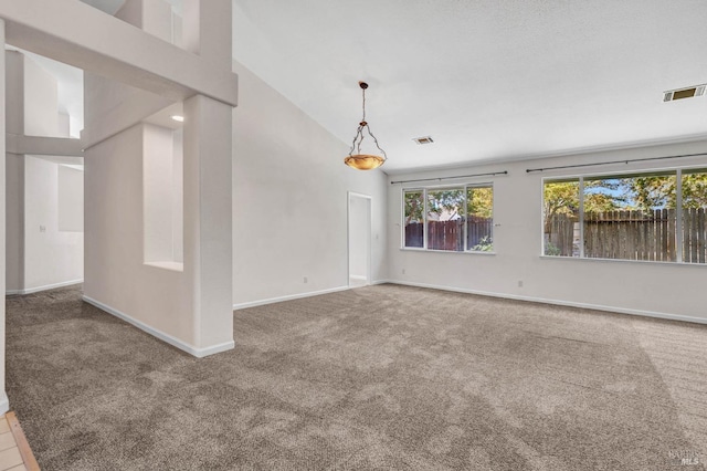 carpeted spare room with high vaulted ceiling