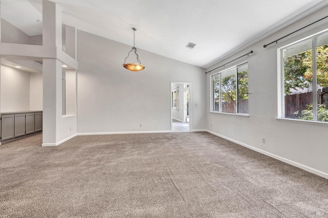 carpeted empty room with high vaulted ceiling