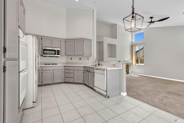 kitchen featuring sink, light colored carpet, white dishwasher, decorative light fixtures, and black cooktop