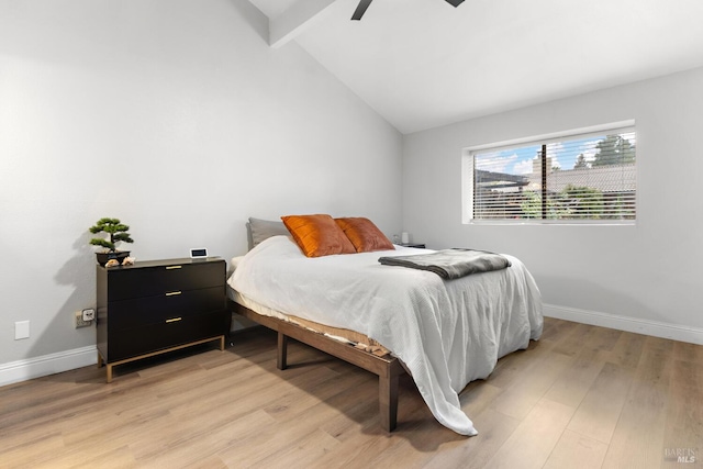 bedroom featuring lofted ceiling with beams, light hardwood / wood-style floors, and ceiling fan