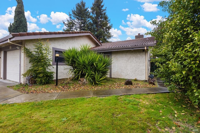 view of home's exterior featuring a garage and a lawn