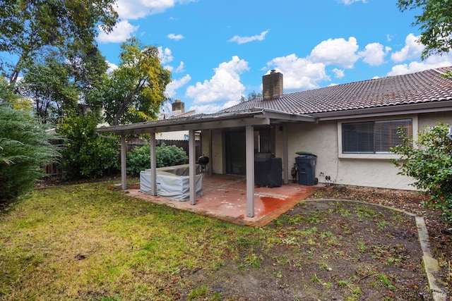 rear view of property with a yard and a patio area