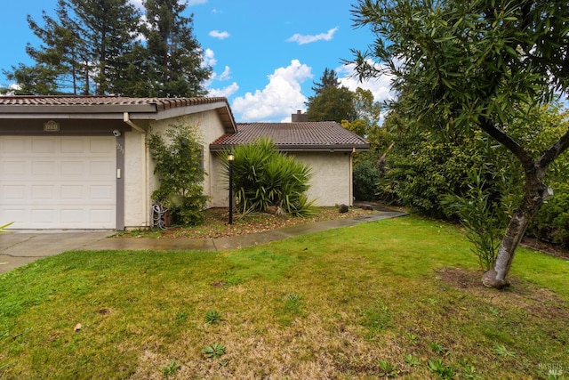 view of property exterior with a garage and a yard