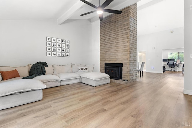 living room featuring high vaulted ceiling, a fireplace, beamed ceiling, ceiling fan, and light hardwood / wood-style flooring