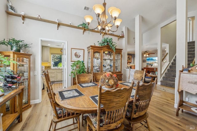 dining area featuring ceiling fan with notable chandelier and light hardwood / wood-style floors