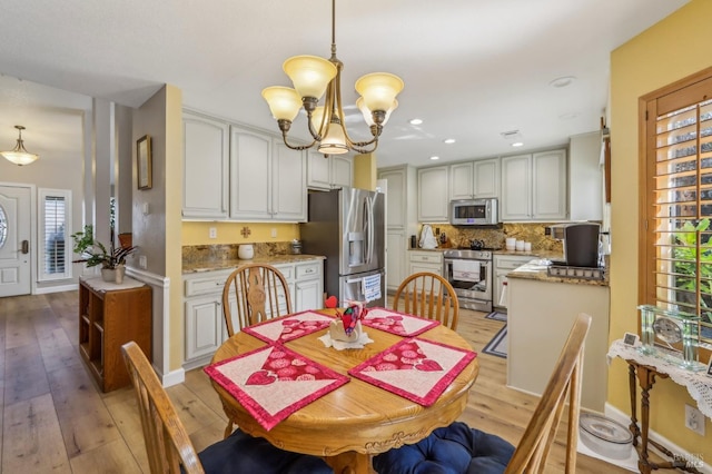 dining room featuring light hardwood / wood-style floors and a chandelier