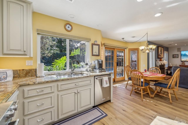 kitchen with pendant lighting, dishwasher, sink, light hardwood / wood-style floors, and cream cabinets