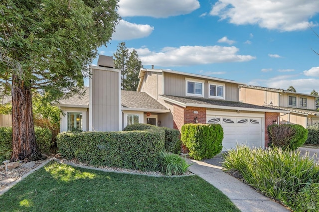 townhome / multi-family property featuring a garage and a front yard