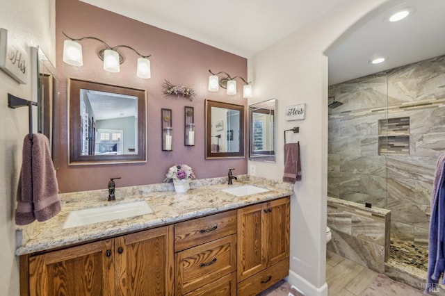 bathroom featuring vanity, toilet, and tiled shower