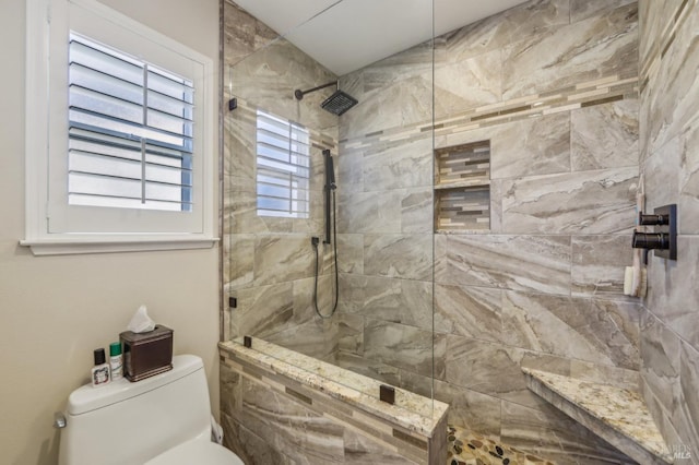 bathroom with tiled shower and toilet