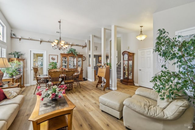 living room with light hardwood / wood-style flooring and a notable chandelier