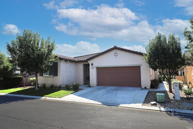 mediterranean / spanish-style home with stucco siding, concrete driveway, a front lawn, a garage, and a tile roof