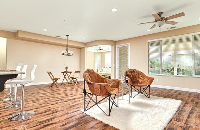 kitchen with dark hardwood / wood-style floors, decorative light fixtures, a kitchen breakfast bar, and stainless steel fridge with ice dispenser