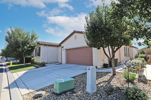 mediterranean / spanish-style house with stucco siding, driveway, a tile roof, and an attached garage