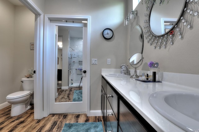 bathroom featuring vanity, toilet, hardwood / wood-style floors, and a shower