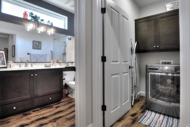 interior space with dark wood-type flooring, cabinets, washer / dryer, and sink