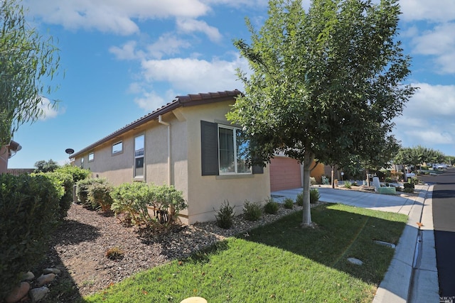 view of property exterior featuring a garage and a yard