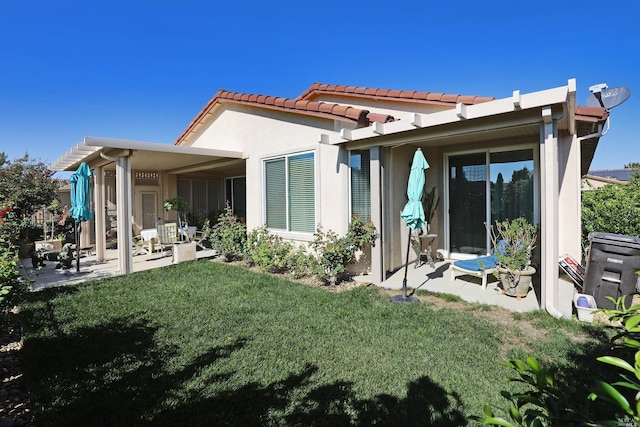 rear view of house with a patio and a lawn