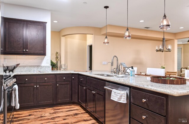 kitchen with pendant lighting, sink, light stone countertops, and a chandelier