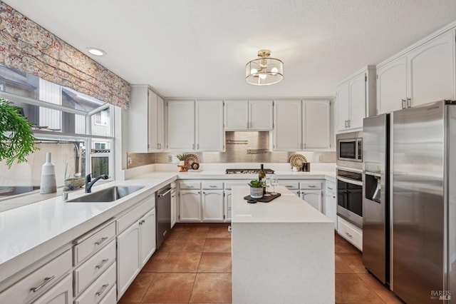 kitchen featuring tile patterned flooring, stainless steel appliances, light countertops, and a sink