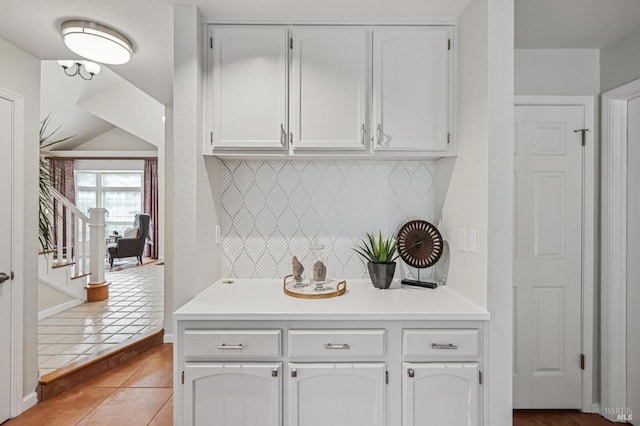 bar featuring light tile patterned floors, baseboards, and tasteful backsplash