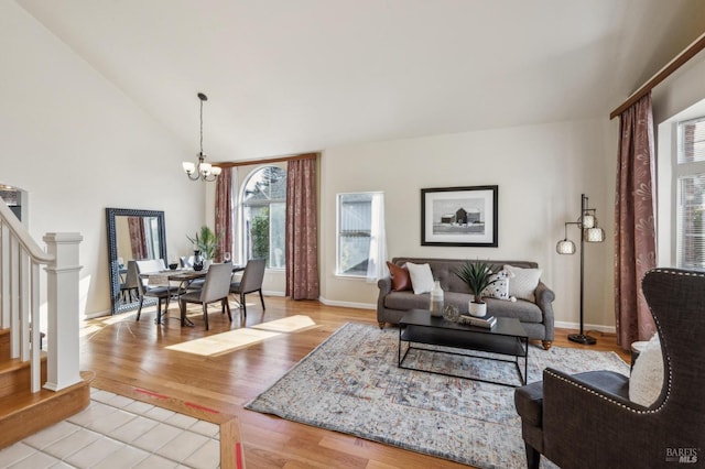 living room with lofted ceiling, a chandelier, baseboards, stairs, and light wood-type flooring