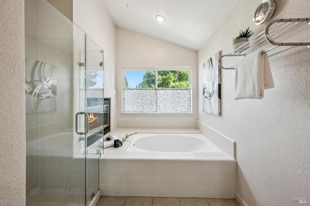 full bathroom featuring a stall shower, lofted ceiling, a bath, and tile patterned flooring