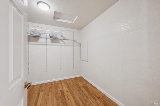 walk in closet featuring attic access and light wood-style flooring