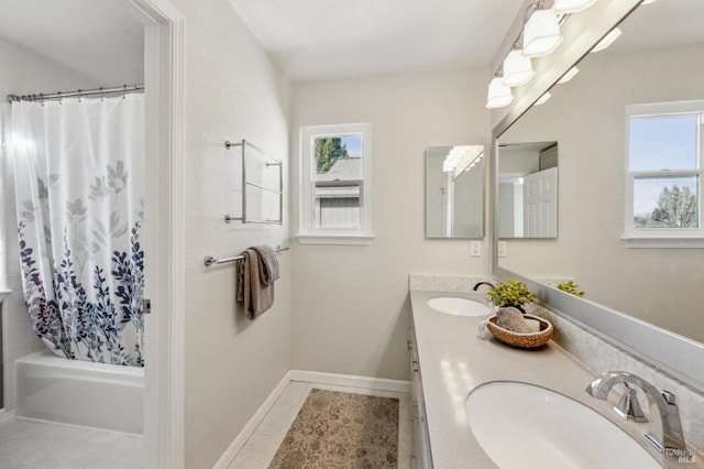 bathroom featuring a sink, shower / bath combo with shower curtain, double vanity, and tile patterned floors