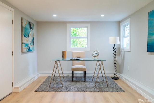 home office featuring wood finished floors, a wealth of natural light, and baseboards