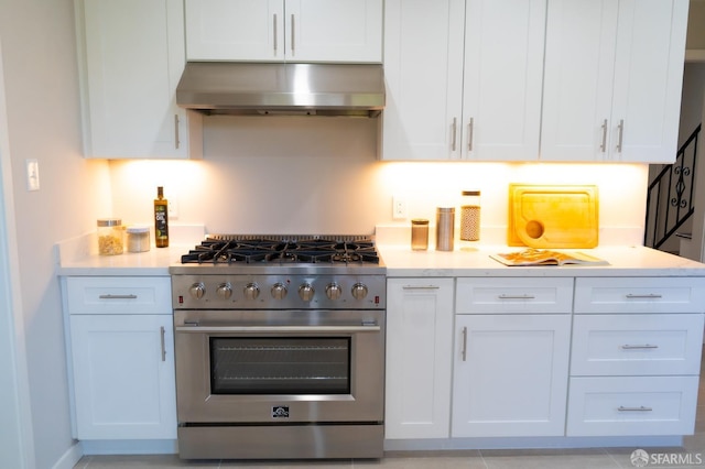 kitchen featuring light countertops, high end stainless steel range, white cabinets, and under cabinet range hood