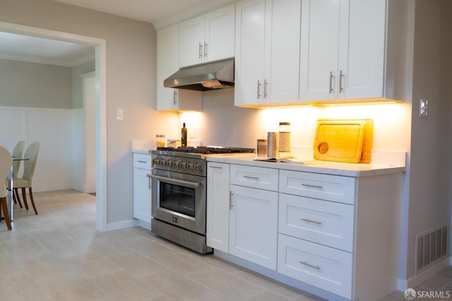 kitchen featuring stainless steel range, light countertops, visible vents, white cabinetry, and under cabinet range hood