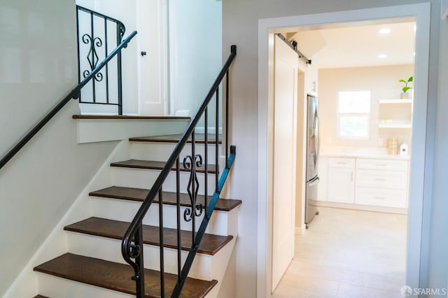 stairway featuring a barn door and recessed lighting