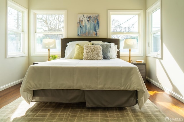 bedroom featuring baseboards and wood finished floors