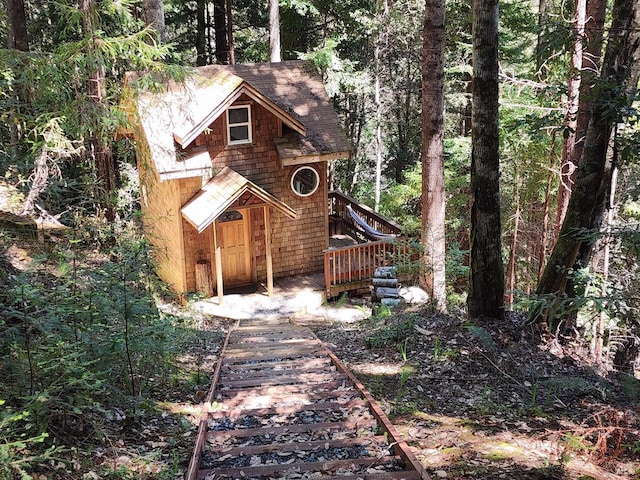 rustic home featuring a shingled roof