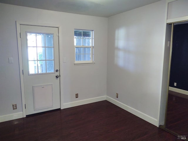 doorway to outside with dark wood-style flooring and baseboards