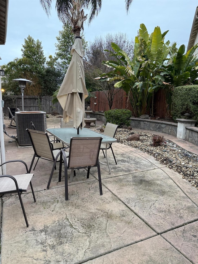 view of patio / terrace featuring cooling unit, outdoor dining area, and a fenced backyard