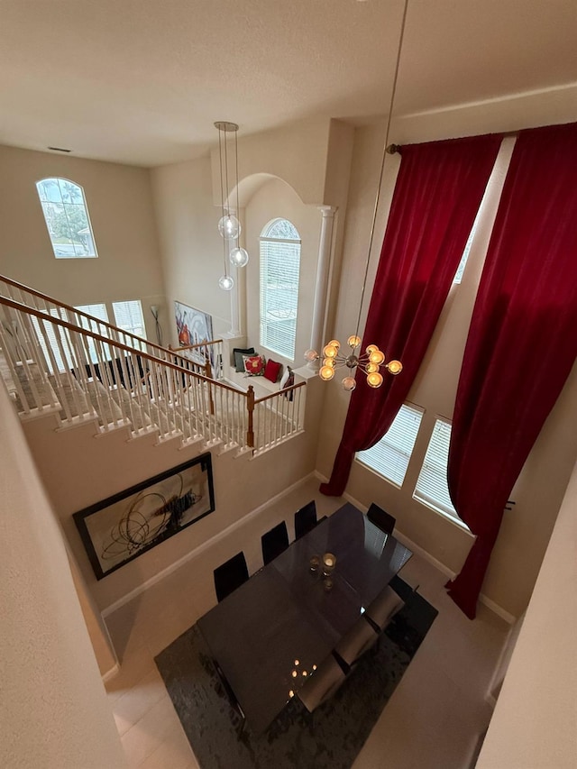 dining space featuring ornate columns, baseboards, and a chandelier