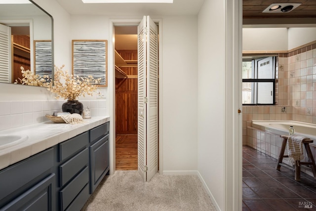 bathroom featuring vanity and a relaxing tiled tub