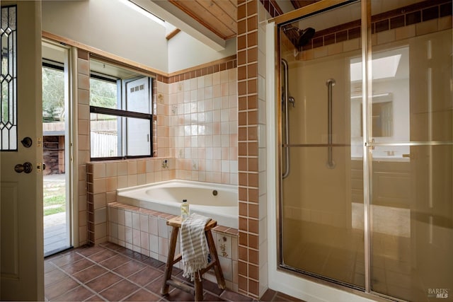 bathroom with independent shower and bath, tile patterned flooring, and tile walls