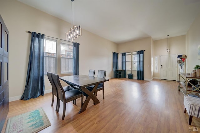 dining room featuring baseboards, a notable chandelier, and light wood-style floors