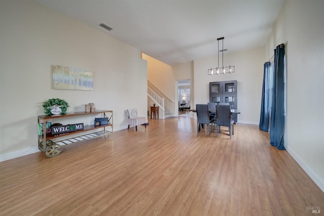 interior space with light wood-type flooring, baseboards, stairs, and visible vents