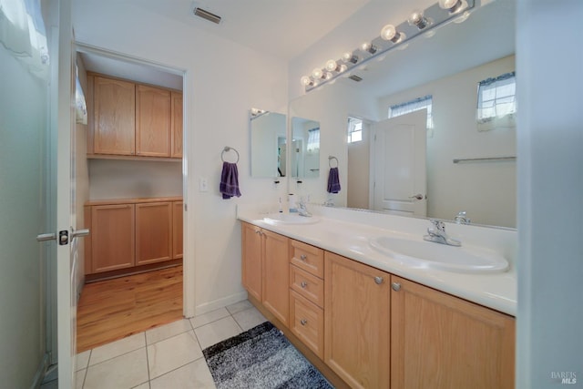 full bath featuring tile patterned flooring, visible vents, a sink, and double vanity
