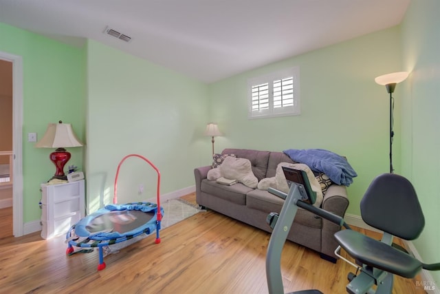 playroom with baseboards, visible vents, and wood finished floors