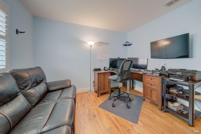 home office with light wood-type flooring, visible vents, and baseboards